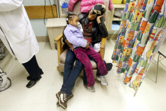 In a file photo, a five-year-old child is treated in a New York City emergency room after an asthma attack. A week ago, the city experienced its highest number of asthma-related ER visits so far in 2023. Credit: Mario Tama/Getty Images.