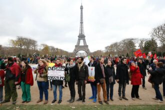 A demonstrator holds a banner reading "Energy liberate-ourselves from our fossil addictions" during a rally called by several NGOs to form a human chain near the Eiffel Tower in Paris on Dec. 12, 2015 on the sidelines of the COP21, the UN conference on global warming. Credit: Francois Guillot/AFP via Getty Images