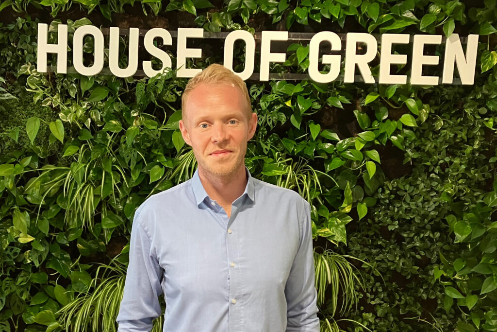 Magnus Højberg Mernild poses in front of a sign at the offices of State of Green, a partnership between the Danish government and clean energy businesses. Credit: Dan Gearino/Inside Climate News
