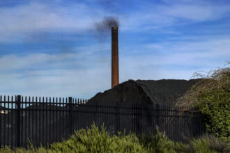 In 2018, a smokestack on the site of then-ERP Coke, within the EPA's 35th Avenue Superfund site in north Birmingham, Alabama. The facility was sold in 2019 to the family of West Virginia Gov. Jim Justice, and is now called Bluestone Coke. The facility temporarily ceased operations in 2021, but still owes the Jefferson County Health Department almost $300,000 in fines and penalties for air pollution violations. Credit: Bonnie Jo Mount/The Washington Post via Getty Images