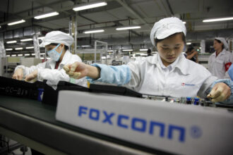 Employees work on the assembly line at Hon Hai Group's Foxconn plant in Shenzhen, China. Foxconn is thought to be a producer of Apple’s watches, but it’s not clear what mix of renewable versus fossil energy it uses in its various factories. Credit: In Pictures Ltd./Corbis via Getty Images.