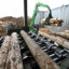 An excavator loads logs used for wood pellets at a sawmill.