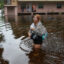 In Tarpon Springs, Florida, Makatla Richter wades through flood waters after having to evacuate her home when the flood waters from Hurricane Idalia inundated it on Wednesday. Credit: Photo by Joe Raedle/Getty Images.