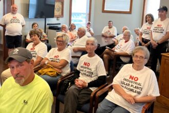 Opponents of solar power crowd into the boardroom of the Pickaway County Board of Commissioners in Circleville, Ohio on Aug. 23. They were there to watch a reporter interview the commissioners about solar power. Chris Weaver is seated on the lower left. Credit: Dan Gearino