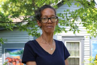 Annie Moore, an English Avenue resident on Atlanta's west side, believes the lump of black rock on her lawn is lead-tainted slag. She worries that if the EPA replaces her dirt, it will lead to flooding on her property. Credit: Aydali Campa