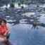 Judith Kimerling kneeling on pipelines above a drilling waste pit in the Ecuadorian Amazon in July 1990. Credit: Courtesy of Judith Kimerling