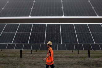 A worker walks past a solar facility in Hill County, Texas in March 2023. Credit: Mark Felix/ AFP/Getty Images