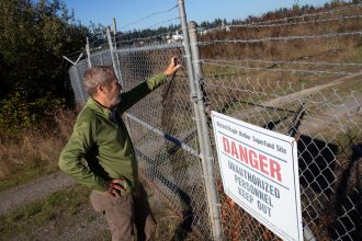 Michael Cox, a former EPA climate expert for the Pacific Northwest, looks into the Wyckoff/Eagle Harbor Superfund site on Bainbridge Island, Washington on Oct. 6, 2020. Credit: Karen Ducey